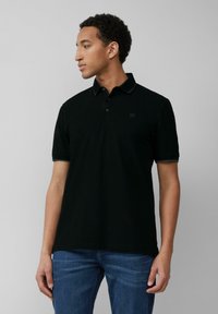 Czarna koszulka polo z bawełny, z trzema guzikami, krótkimi rękawami i subtelnym logo na lewej części klatki piersiowej.