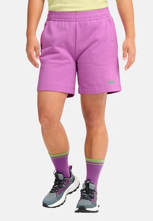 Lila Baumwollshorts mit elastischem Bund und Seitentaschen, kombiniert mit grauen Turnschuhen und lila-grün gestreiften Socken.