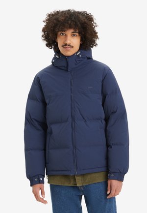 Marineblaues Daunenjacke mit hohem Kragen, Reißverschluss und zwei Fronttaschen. Verfügt über elastische Bündchen und eine strukturierte Oberfläche.