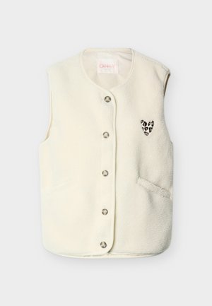 Λευκό γιλέκο από μάλλινο ύφασμα με στρογγυλή λαιμόκοψη, μεταλλικά κουμπιά και μικρό μπαλώμα σε σχήμα καρδιάς με λεοπάρ σχέδιο στη αριστερή πλευρά. Διαθέτει πλαϊνές τσέπες.