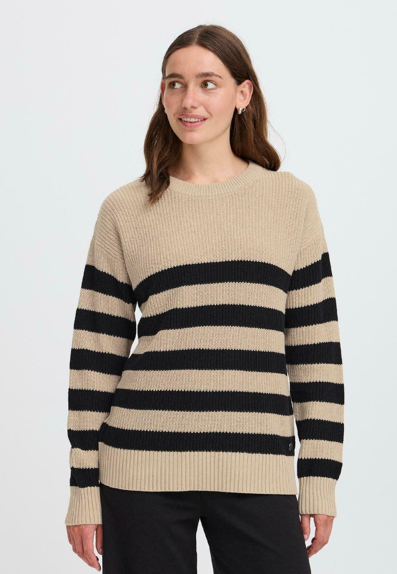 Maglione a strisce beige e nere con texture a costine, scollo rotondo e maniche lunghe. Presenta una vestibilità leggermente ampia e strisce a contrasto.