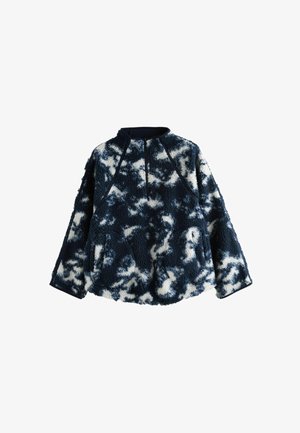 Fleece-pullove r sinimusta ja valkoista kamuflaažikuosia, jossa on pitkät hihat, korkea kaulus ja teksturoitu kangas. Korostettu tummilla yksityiskohdilla.