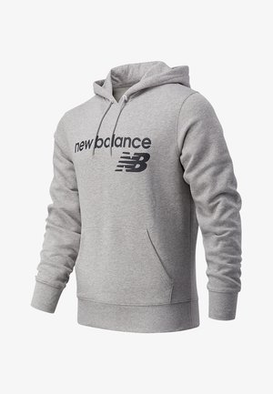 Jasnoszara bluza z kapturem New Balance z kieszenią z przodu, kapturem z regulacją na sznurek i czarnym napisem logo na piersi.