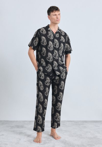 Schwarzes Schlafanzugset mit kurzärmeligem Shirt und langen Hosen, versehen mit einem cremefarbenen Tiger-Muster, aus leichtem Stoff mit glatter Textur.