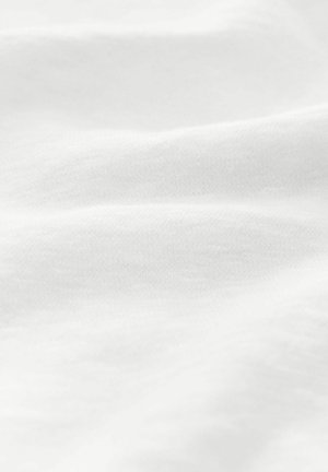 Tessuto di cotone bianco con una texture liscia, che mostra morbide pieghe e sottili variazioni di luminosità. Nessun motivo o hardware visibile.