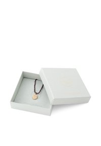 Collier avec pendentif en or à design texturé sur une chaîne de perles marron, présenté dans une boîte gris clair avec un logo et un intérieur doux.