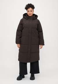 Dark brown, puffer-style long coat with a hood, front zipper, large pockets, and elastic cuffs, featuring a quilted texture.