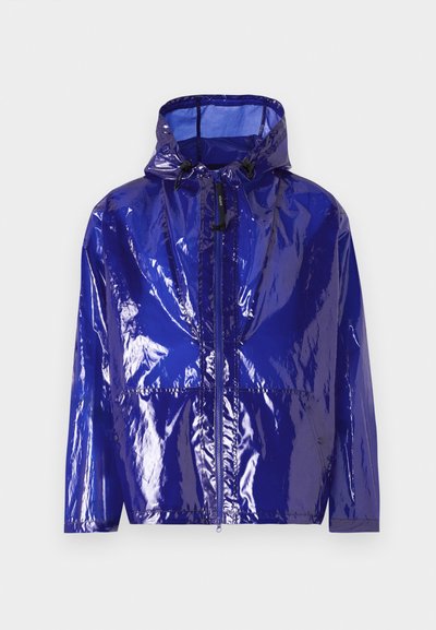 Lilla, glansfuld regnjakke med hætte. Har en frontlynlås, justerbar snoretræk og en tekstureret, skinnende overflade.