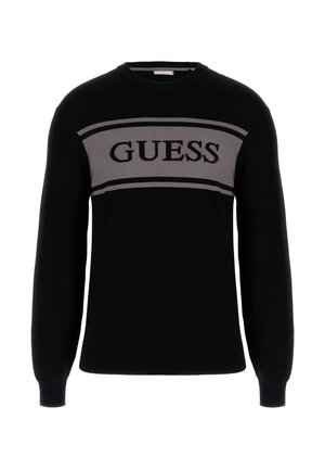Pull en tricot noir avec une bande horizontale grise portant le texte "GUESS" en gras noir sur la poitrine. Col rond, manches longues.