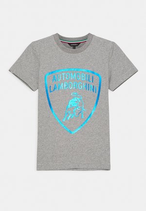 Camiseta gris de manga corta con un logo metálico azul de Lamborghini y texto "Automobili Lamborghini" en el frente.