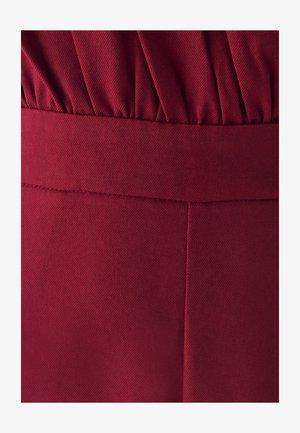 Tela burdeos con un patrón texturizado y acanalado; cuenta con una cinturilla fruncida y un acabado suave con detalles de costura visibles.