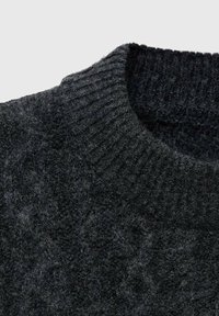 Maglione nero lavorato a maglia con scollatura a coste, caratterizzato da una superficie testurizzata. Il tessuto appare morbido e leggermente peloso.
