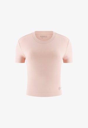 Kort rosa figurnära T-shirt med rund hals och korta ärmar. Slenyta, har en diskret "Guess"-logotyp i metalltråd vid fållen.