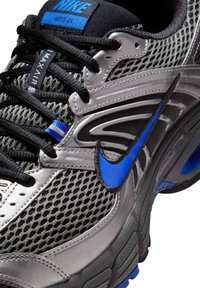 Svart och blå Nike Air Max Moto 2K-sneaker med ovandel i mesh, detaljerad sömnad och synlig Nike-swoosh på sidan.