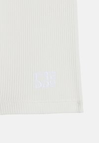 Tejido blanco acanalado con una textura suave y un ligero estiramiento. Presenta el logotipo bordado "FREDDY" en blanco en la esquina inferior derecha.