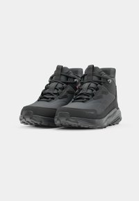 Black high-top hiking shoes featuring a textured upper, supportive collar, and rugged outsole with prominent lugs for traction.