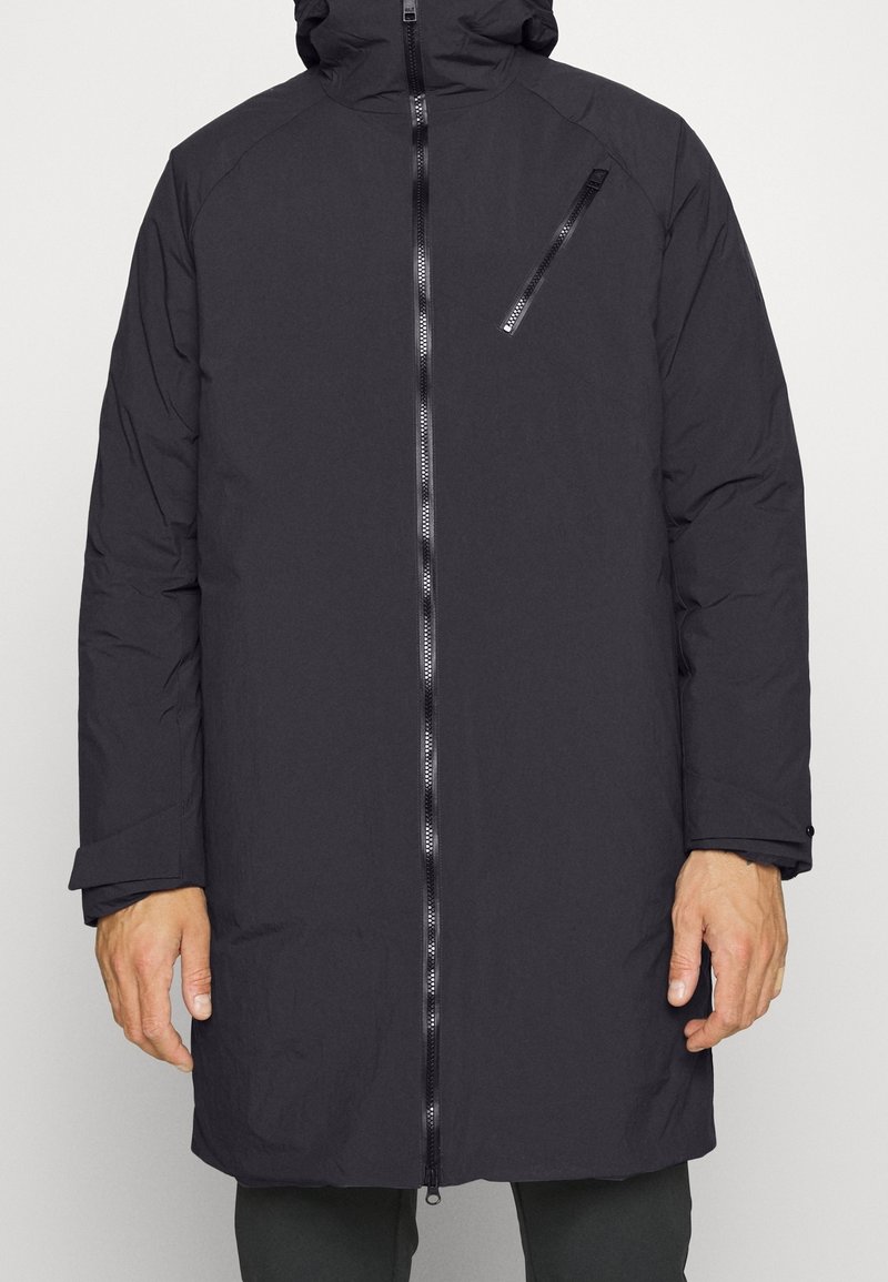 Svart vadderad jacka med huva, framsida med dragkedja och sidofickor. Den har en elegant design med en texturerad tyg och skräddarsydd passform.