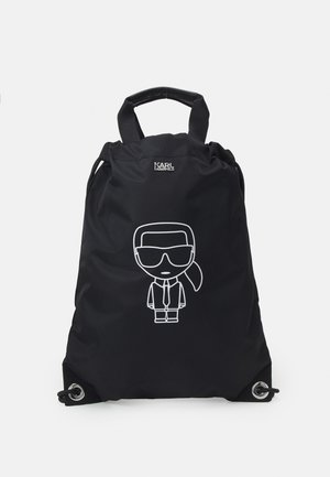 Czarny plecak z trokami, górnymi uchwytami, logo Karl Lagerfeld i białą postacią z kreskówki w okularach przeciwsłonecznych i krawacie na przodzie.