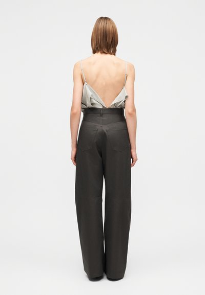 Top cinzento claro sem mangas com decote baixo nas costas, combinado com calças largas de cintura alta em cinzento escuro, com bolsos laterais e textura lisa.