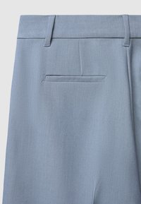 Pantaloni azzurro chiaro realizzati in tessuto lisci; presentano una tasca posteriore singola e passanti per cintura; design sartoriale con pieghe stirate.