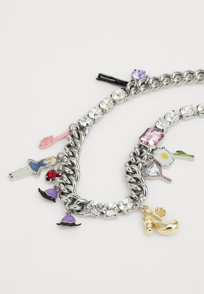 Silverkedjaarmband med färgglada berlocker, inklusive en rosa kam, en guldsandal och olika ädelstenar i metall.