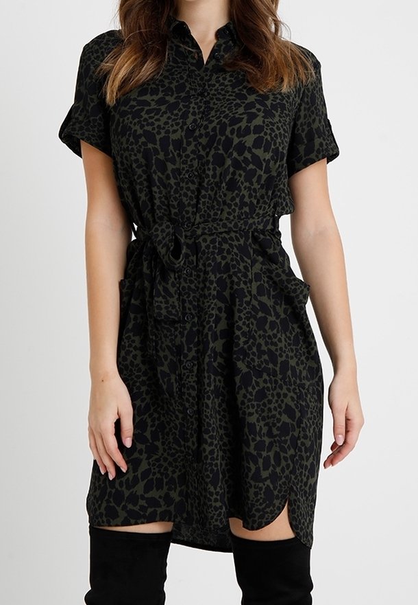 Abito camicia in stampa leopardata verde scuro e nero, maniche corte, chiusura a bottoni sul davanti, vita affusolata con cravatta e spacchi laterali per il movimento.