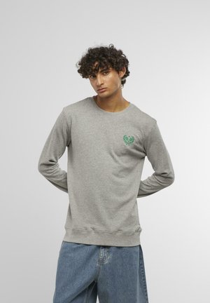 Gray long-sleeve sweatshirt in a soft, textured fabric with a green embroidered emblem on the chest. Relaxed fit with ribbed cuffs and hem.