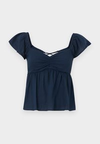 Navy blue peplum top with puff sleeves, gathered detailing at the bust, and crisscross back straps. Made of lightweight fabric.