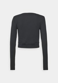 Czarna, krótka bluzka z długim rękawem wykonana z prążkowanego materiału; na dole znajduje się pasek z logo "TOMMY HILFIGER" w ciemnoniebieskim kolorze.