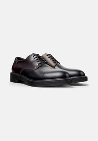 Schwarz-braune Leder Schuhe mit runden Zehen, Schnürdesign, strukturiertem Obermaterial, kontrastierenden Paneelen und Gummisohlen.