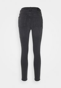 Jeans ajustados negros con una textura suave, cintura alta y dos bolsillos traseros, diseñados para un silueta ajustada.