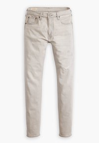 Jean slim beige clair avec cinq poches, passants pour ceinture, boutons et fermeture éclair, et légères zones usées sur les jambes avant.