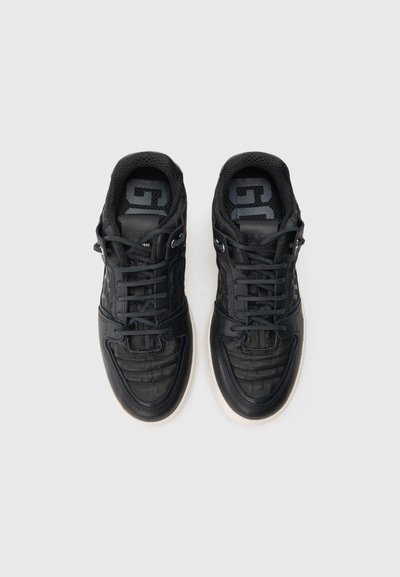 Czarne sneakersy wykonane z teksturowanej skóry, charakteryzujące się niskoprofilowym designem, wyściełanym kołnierzem i białą gumową podeszwą. Sznurowane z wzmocnionymi oczkami.