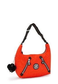 Orange nylon axelväska med två dragkedjefickor, svarta detaljer, en rund logopatch och en svart plyschapa charm hängande.