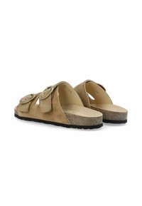 Beige Wildleder-Sandalen mit zwei verstellbaren Schnallenriemen, einer breiten Fußbett und einer strukturierten Korksohle. Flach mit abgerundeten Kanten.