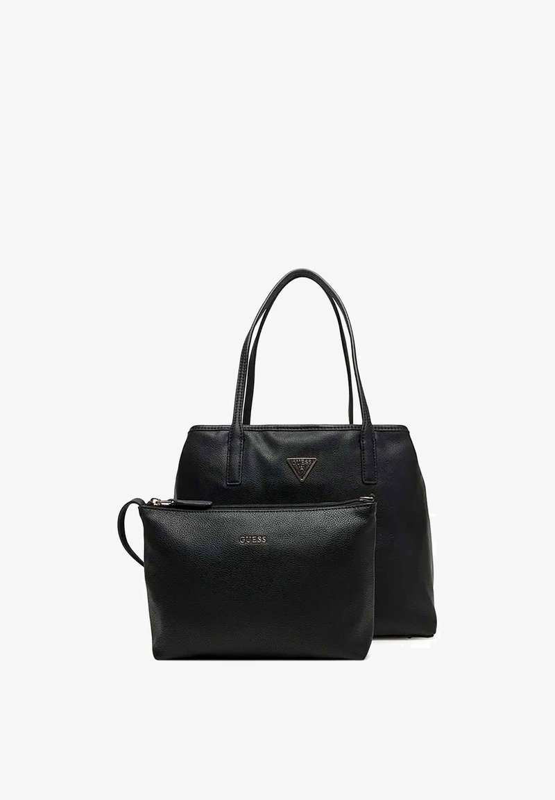 Sac cabas en cuir noir GUESS avec doubles poignées et pochette assortie zippée avec bracelet en cuir devant sur fond blanc.