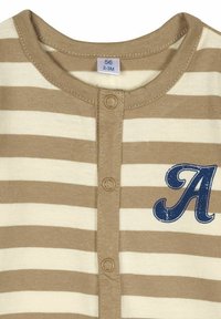 Gestreifter Overall in Beige und Creme, mit Rundhalsausschnitt, Knopfverschluss und einem blauen Buchstaben 'A' Grafik auf der Vorderseite. Das Größenetikett zeigt 56 (2-3 Monate).