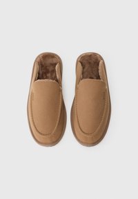 Rudi slip-on šlepetės su minkštu, pūkuotu vidumi ir lygiu išoriniu audiniu. Suapvalintas pirštų dizainas ir kontrastingos siūlės detalės.