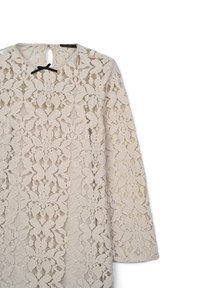 Spitzenkleid in hellbeige mit langen Ärmeln, das mit Blumenmustern und einem runden Ausschnitt verziert ist. Es hat einen Schlüsselloch-Ausschnitt hinten mit einem schwarzen Band.