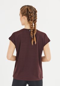 Donker kastanjebruin shirt met korte mouwen, een gestreepte textuur, een ronde halslijn en een losse pasvorm, gecombineerd met zwarte sportbroek.