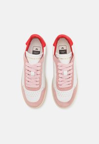 Hvite joggesko med rosa semsket skinn detaljer, rosa lisser og rød hæl. Har perforeringer og "Copenhagen Studios" logo på tungen.