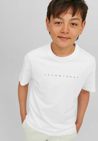 Balta medvilninė marškinėliai su „JACK & JONES“ spauda tamsiai mėlyna spalva. Apvalus kaklas, trumpomis rankovėmis, laisvas siluetas, lygus tekstūra.