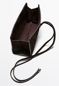 Borsa a mano rettangolare in suede marrone scuro con manici lunghi e sottili, apertura superiore che mostra un ampio interno vuoto.
