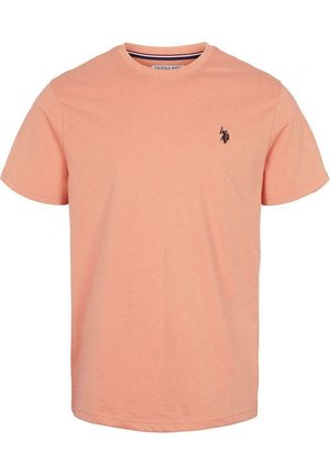 T-shirt à manches courtes en coton pêche clair, avec un col rond et un petit logo noir sur la poitrine gauche. Texture douce.