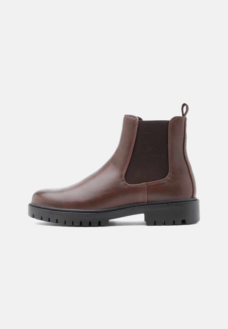 Botte Chelsea en cuir marron avec panneau latéral élastique noir et semelle épaisse en caoutchouc noir sur fond blanc.