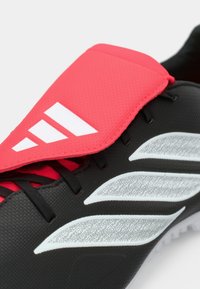 Μαύρο αθλητικό παπούτσι με φωτεινή ροζ, υφασμάτινη άνω φάση. Διαθέτει λευκές ρίγες και λεπτομέρειες στο πλάι, με μαύρα κορδόνια.