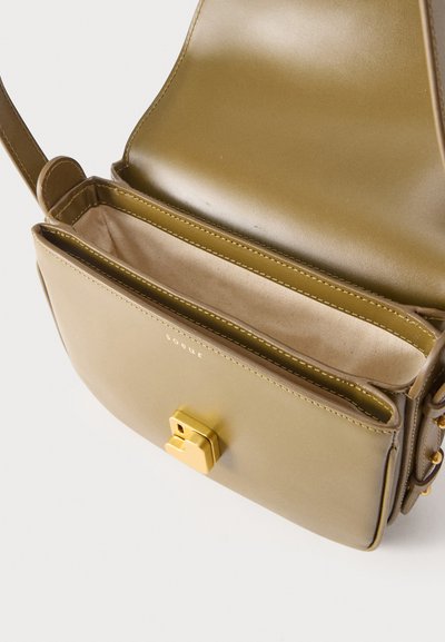 Ανοιχτό καφέ δερμάτινο τσαντάκι χιαστί με επάνω καπάκι ανοιχτό, εσωτερικό από μπεζ ύφασμα και ορθογώνιο κούμπωμα σε χρυσό τόνο μπροστά.