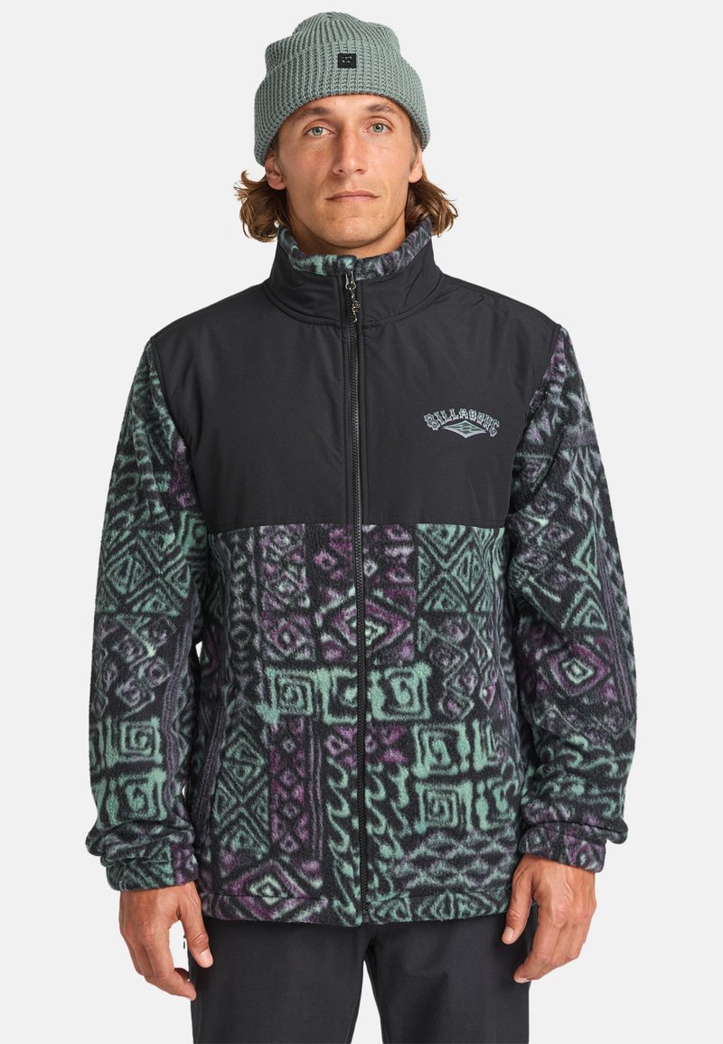 Veste en polaire avec une partie supérieure noire et une partie inférieure à motif vert, violet et noir, dotée d'un col haut et d'une fermeture éclair.