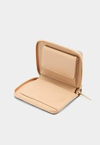 Portafoglio in pelle crema con chiusura a zip, dotato di più slot per carte e una texture interna liscia. Design minimalista con accessori dorati.