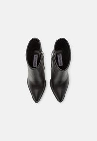 Černé kožené kotníkové boty s špičatou špičkou a bočním zipem. Hladký povrch a elegantní design, vhodné k různým outfitům.
